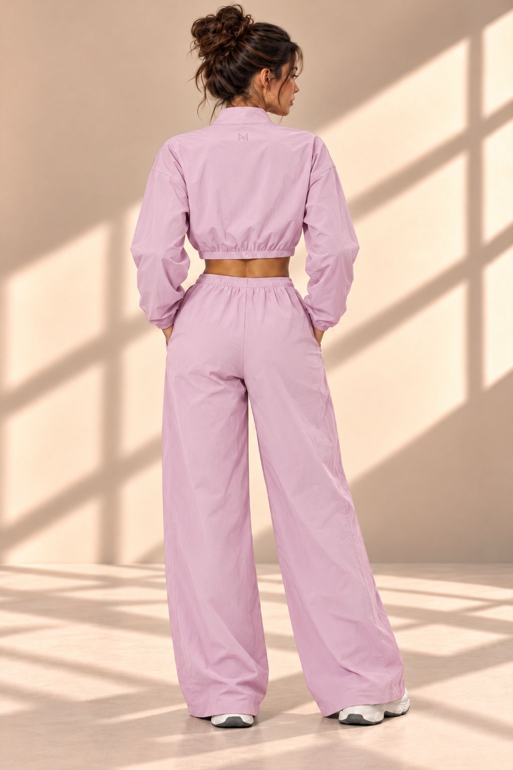 Back view of Blossom Track pink set showing gathered jacket hem and matching wide-leg pants