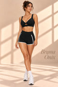 Front view of Bruma Onix black twist-front top and shorts with white piping