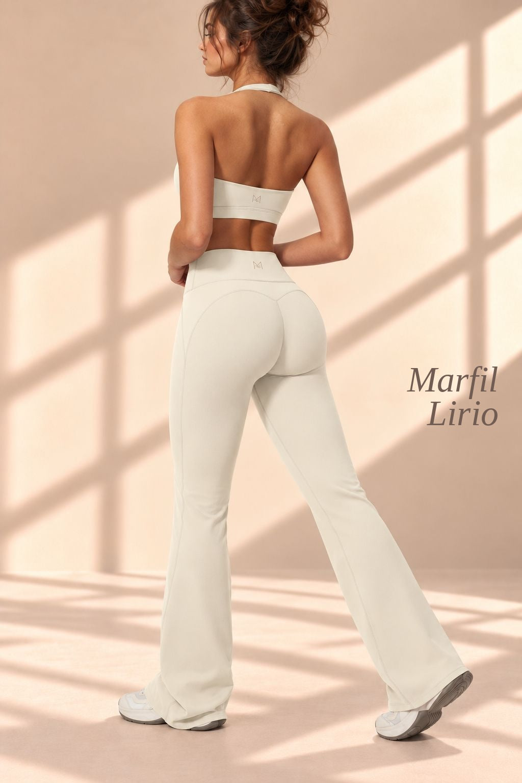 Front view of Marfil Lirio ivory halter crop top and flare pants