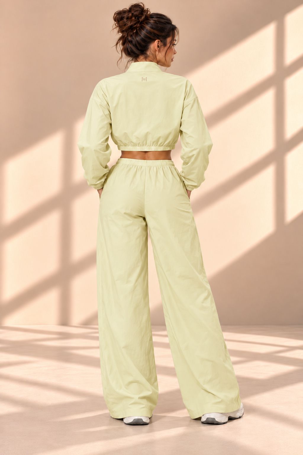 Back view of Matcha Track pale green set showing gathered jacket hem and matching wide-leg pants