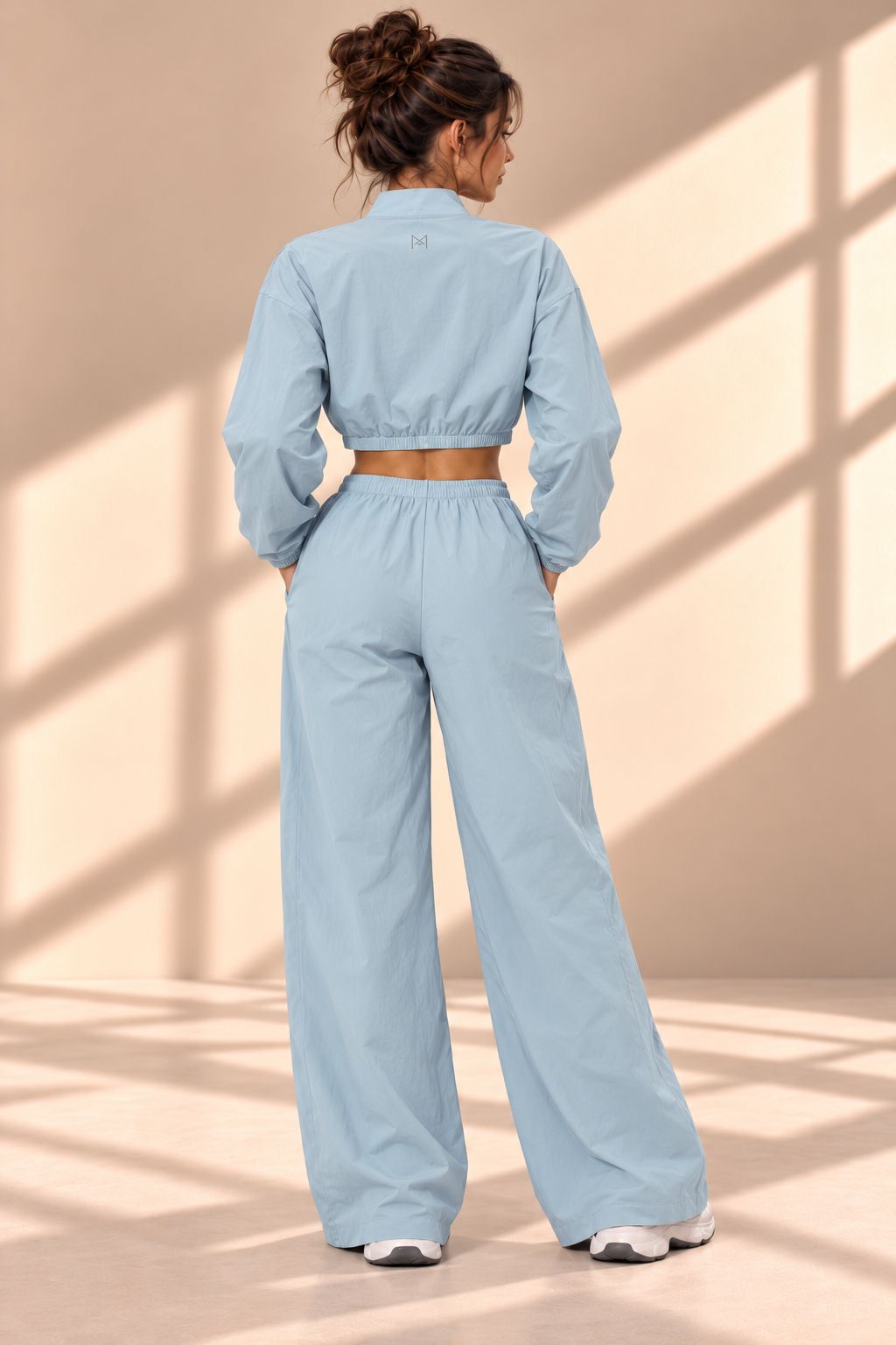 Back view of Powder Track blue set showing gathered jacket hem and matching wide-leg pants